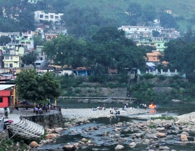 A view of the confluence of the Gomti and Saryu rivers with a funeral fire burning where they meet. Baghunath Temple, Bageshwar, Uttarakhand.