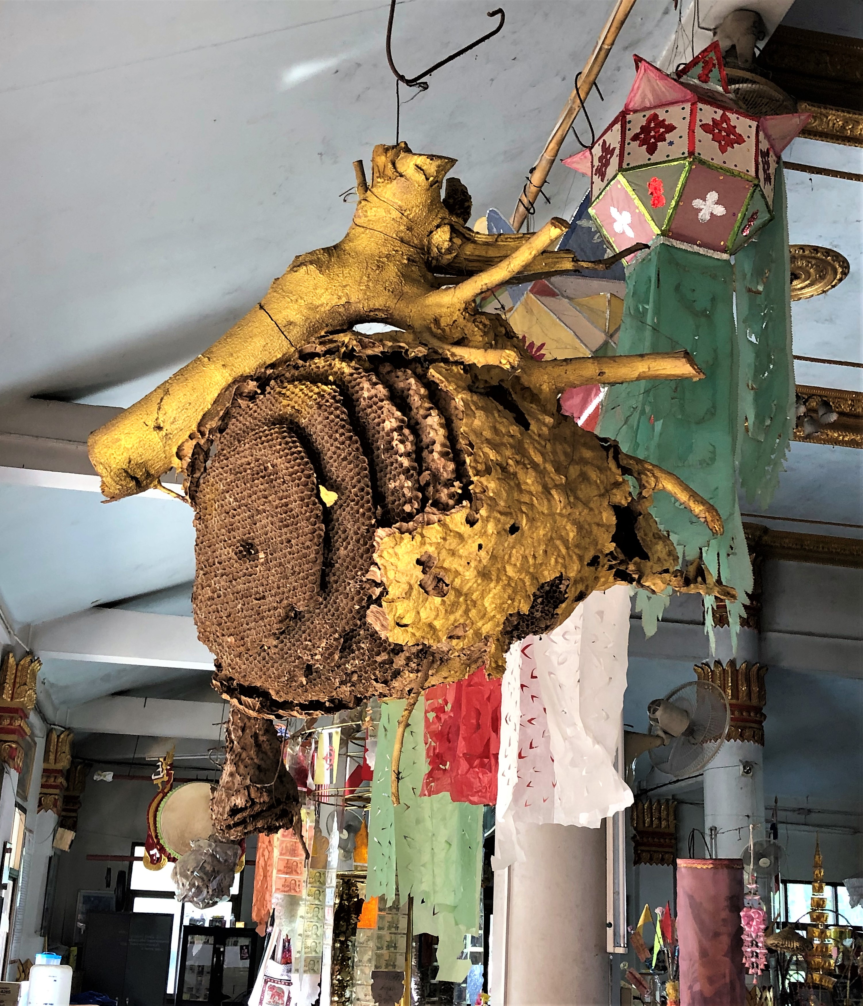 A honeycomb, gilded, hangs from the ceiling of the main temple